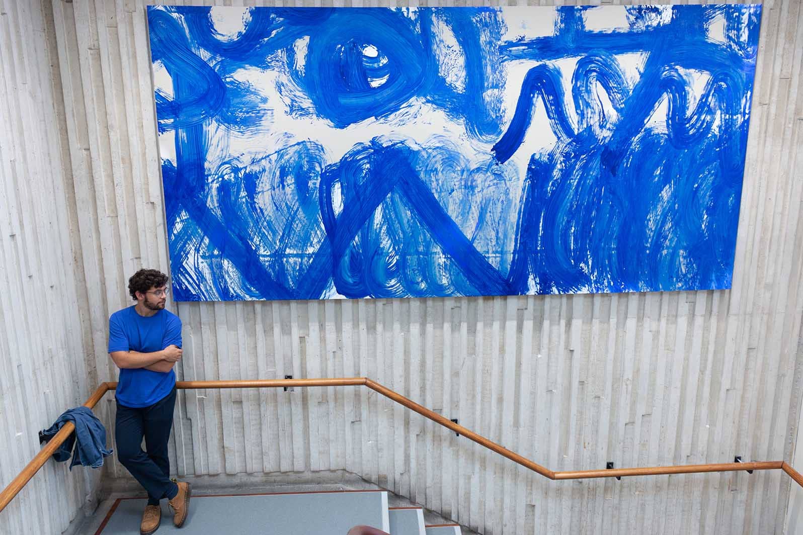 Jos&eacute; Garcia Oliva standing beside one of the canvases created by Lancaster cleaning staff